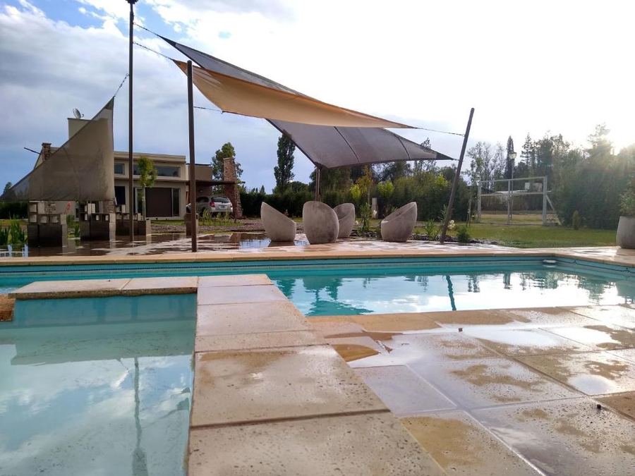 Pileta con carpas de sombra y living exterior