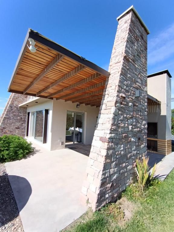 Frente del chalet con parrilla y pérgola